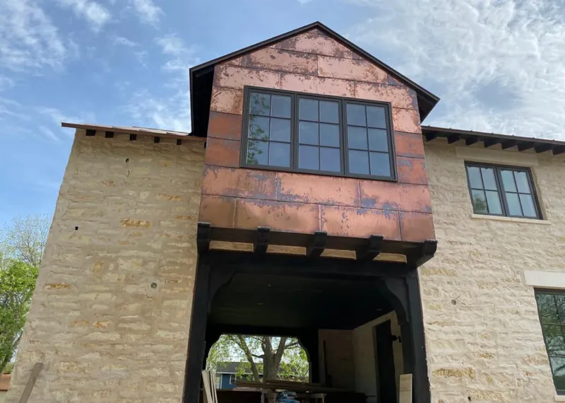 Copper metal panel facade on a stone building for Metal Roof Coating in Lysander